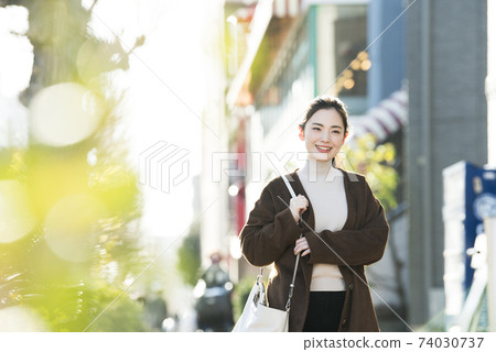 A young lady walking in the city 74030737