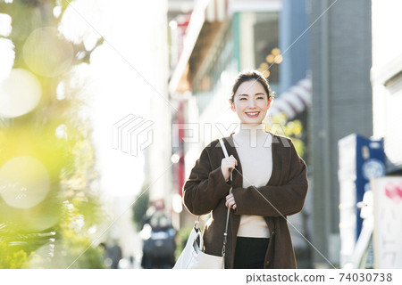 A young lady walking in the city 74030738