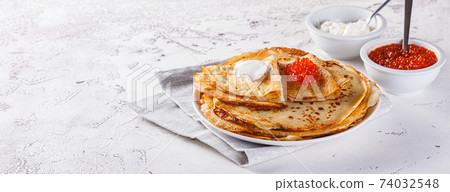 Stack of russian pancakes blini with red caviar, fresh sour cream 74032548