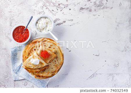 Stack of russian pancakes blini with red caviar, fresh sour cream 74032549