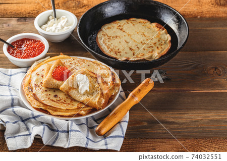 Stack of russian pancakes blini with red caviar, fresh sour cream 74032551