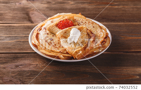 Stack of russian pancakes blini with red caviar, fresh sour cream 74032552