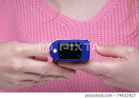 Close up of Finger and hand in an Oximeter Device.  74032927
