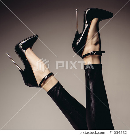 Slender female legs in spandex catsuit and a fetish shoe with extremely high heels. 74034282