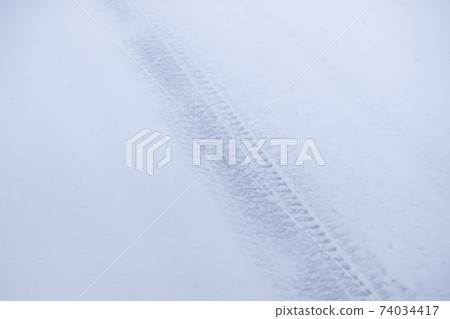 Traces of car tires left on snow accretion 74034417