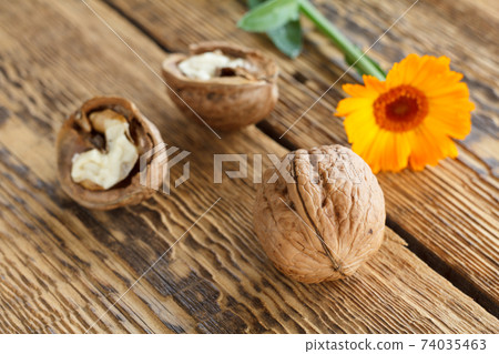 Walnuts and flower over the wooden natural background 74035463