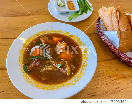 Delicious stewed beef brisket served with baguette bread - Bo Kho 74035694