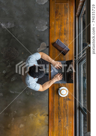 Vertical top view of Asian freelancer typing on laptop  74035719