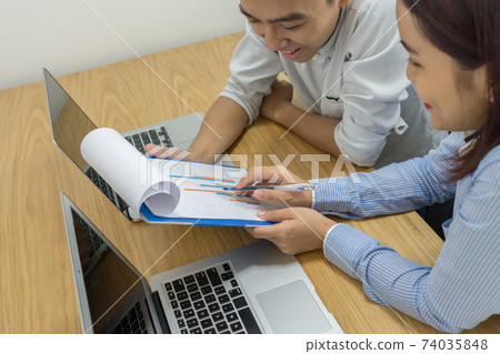 Business employee discuss about information on sales report 74035848