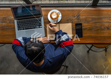 Young stock broker analyzing financial candlestick graph on laptop Young stock broker analyzing financial candlestick graph on laptop 74036157