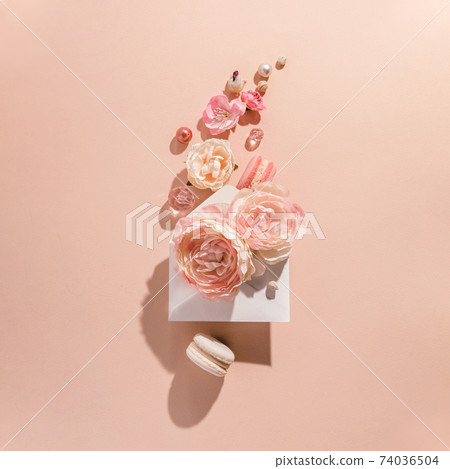 Floral explosion, flowers in motion from an envelope on a peach background. Muted monochrome, trendy concept. Floral explosion, flowers in motion from an envelope on a peach background. Muted monochrome, trendy concept. 74036504