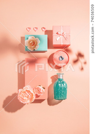 Festive geometric arrangement of gift boxes and flowers in pastel colors with sunny shadows Festive geometric arrangement of gift boxes and flowers in pastel colors with sunny shadows 74036509