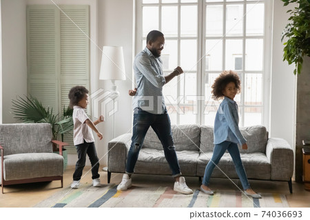 Full length African American father with kids dancing at home 74036693