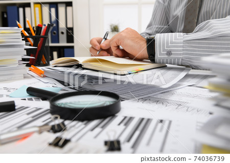 business concept - businessman working with reports in office, table and workspace close view, analyzing financial data, writes and counts 74036739