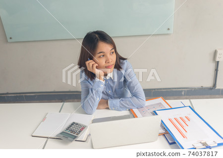 Young Asian office woman thinking and working in business office Young Asian office woman thinking and working in business office 74037817