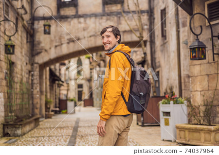 Young man tourist walks down the street in a European city after the end of COVID-19 coronavirus. quarantine is over 74037964