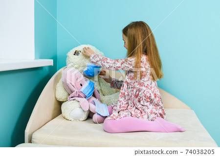 Small girl wear mask on teddy bear Small girl wear mask on teddy bear 74038205
