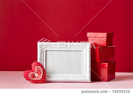 Photo frame and Valentines day hearts and decorations on red background. 74039338