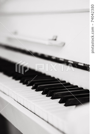 Beautiful white piano with the open keyboard Beautiful white piano with the open keyboard 74042380