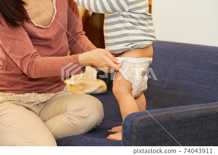 Changing baby diapers while standing Changing baby diapers while standing 74043911
