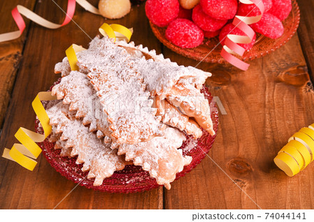 Carnival TYPICAL food and Confetti. Sfrappole or chiachiere or angel wings and aromatic coffee on a 74044141