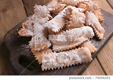 Italian Carnival and TYPICAL food. Sfrappole or chiachiere or angel wings on a woody background 74044201