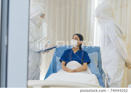 Group of covid-19 quarantine specialist team in ppe uniform working with corona virus infected patient in control room at hospital. Coronavirus treatment and prevention concept. Group of covid-19 quarantine specialist team in ppe uniform working with corona virus infected patient in control room at hospital. Coronavirus treatment and prevention concept. 74044202