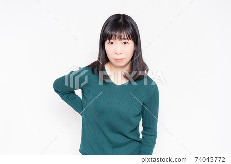 A woman standing in front of a white background with her hands on her hips 74045772