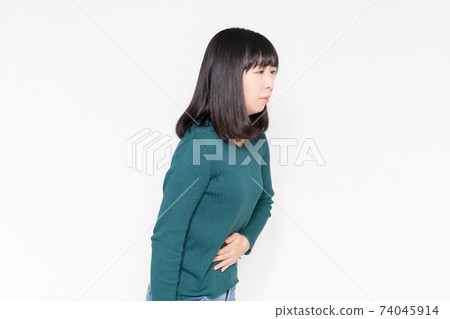 站立在白色背景前面和握她的手的婦女在她的腹部上 74045914