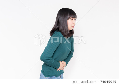 站立在白色背景前面和握她的手的婦女在她的腹部上 站立在白色背景前面和握她的手的婦女在她的腹部上 74045915