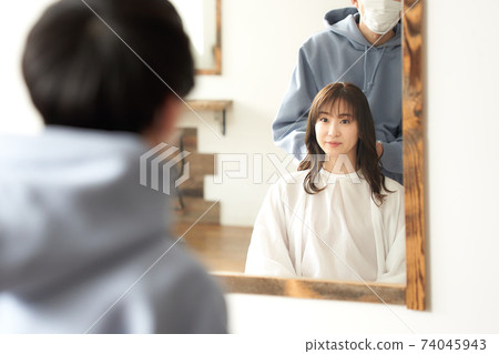 戴著面具和年輕的女性顧客的美容師的形象 74045943