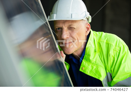portrait of a engineer looking on solar cell panel. 74046427