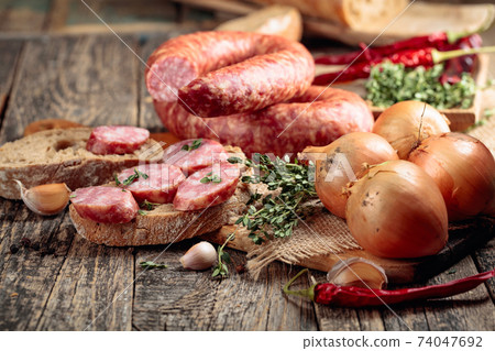 Sausage with bread and spices on a old wooden table. 74047692