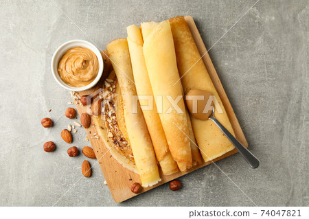 Concept of delicious breakfast with crepes with peanut butter and nuts on gray table 74047821