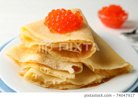 Plate of crepes with red caviar, close up 74047917