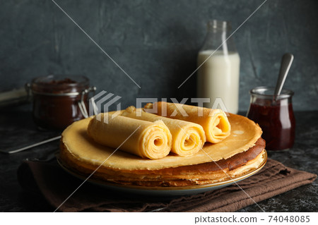 Concept of breakfast with crepes rolls on black smokey table Concept of breakfast with crepes rolls on black smokey table 74048085