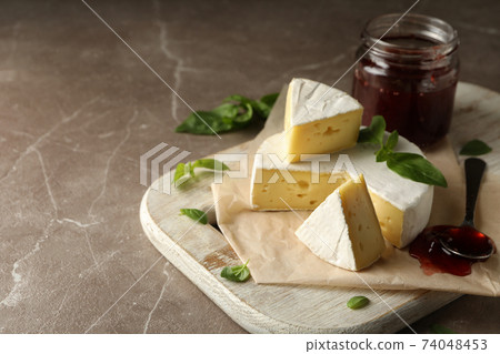 Concept of tasty eating with camembert and jam on cutting board Concept of tasty eating with camembert and jam on cutting board 74048453