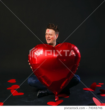 valentines red heart, balloon in hands, sexy healthy. On a black background crazy cheerful, smile valentines red heart, balloon in hands, sexy healthy. On a black background crazy cheerful, smile 74048746