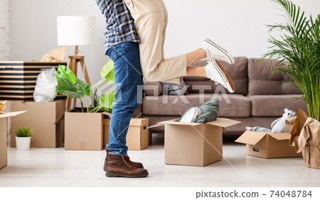 Couple embracing in new flat with carton boxes 74048784