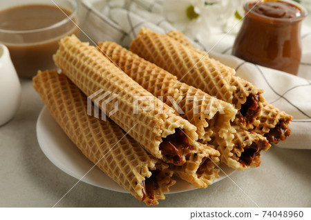 Concept of tasty breakfast with wafer rolls with condensed milk Concept of tasty breakfast with wafer rolls with condensed milk 74048960