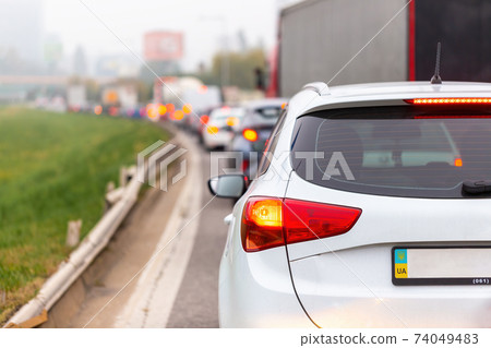 Cars waiting in traffic jam with illuminated brake lights 74049483