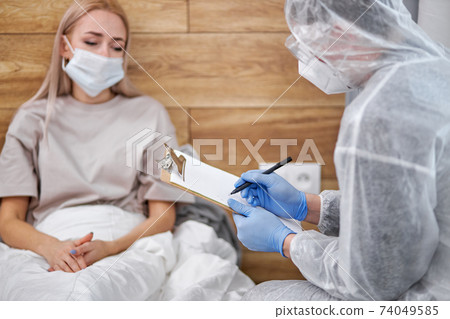 unknown man-doctor and patient discussing current health examination while sitting at home unknown man-doctor and patient discussing current health examination while sitting at home 74049585