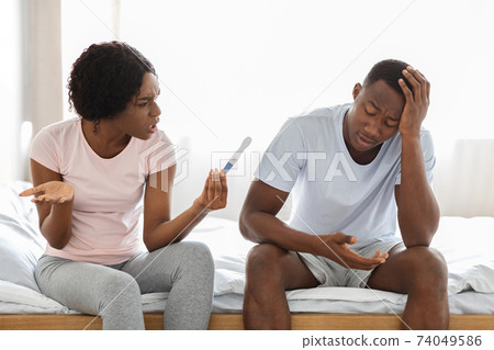 Angry black woman with pregnancy test yelling at her boyfriend Angry black woman with pregnancy test yelling at her boyfriend 74049586