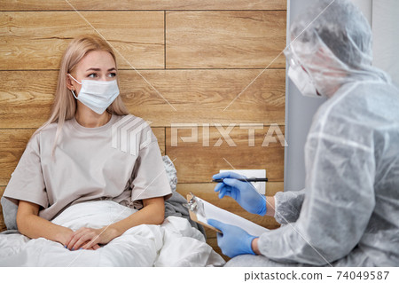 unknown man-doctor and patient discussing current health examination while sitting at home unknown man-doctor and patient discussing current health examination while sitting at home 74049587
