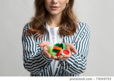 Unrecognizable Lady Holding Colorful Plastic Lids Bottle Cups In Hands Unrecognizable Lady Holding Colorful Plastic Lids Bottle Cups In Hands 74049793