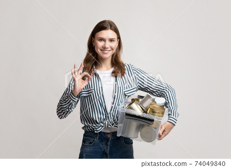 Metal Recycling. Positive Lady Holding Container With Tin Cans, Showing Ok Gesture Metal Recycling. Positive Lady Holding Container With Tin Cans, Showing Ok Gesture 74049840