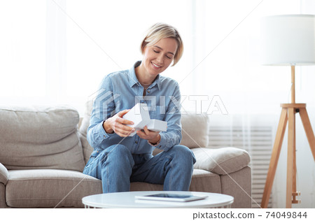 Happy female blogger making video review of new mobile phone, opening box with device, filming content for her vlog Happy female blogger making video review of new mobile phone, opening box with device, filming content for her vlog 74049844