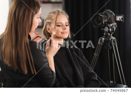 Beautiful woman beauty vlogger doing cosmetic makeup demonstration with her friend in studio Beautiful woman beauty vlogger doing cosmetic makeup demonstration with her friend in studio 74049867