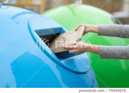 Paperwaste Sorting. Unrecognizable woman throwing carton package into blue garbage recycle bin Paperwaste Sorting. Unrecognizable woman throwing carton package into blue garbage recycle bin 74049878