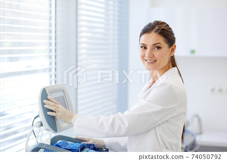 portrait of caucasian female doctor push buttons on medical equipment 74050792